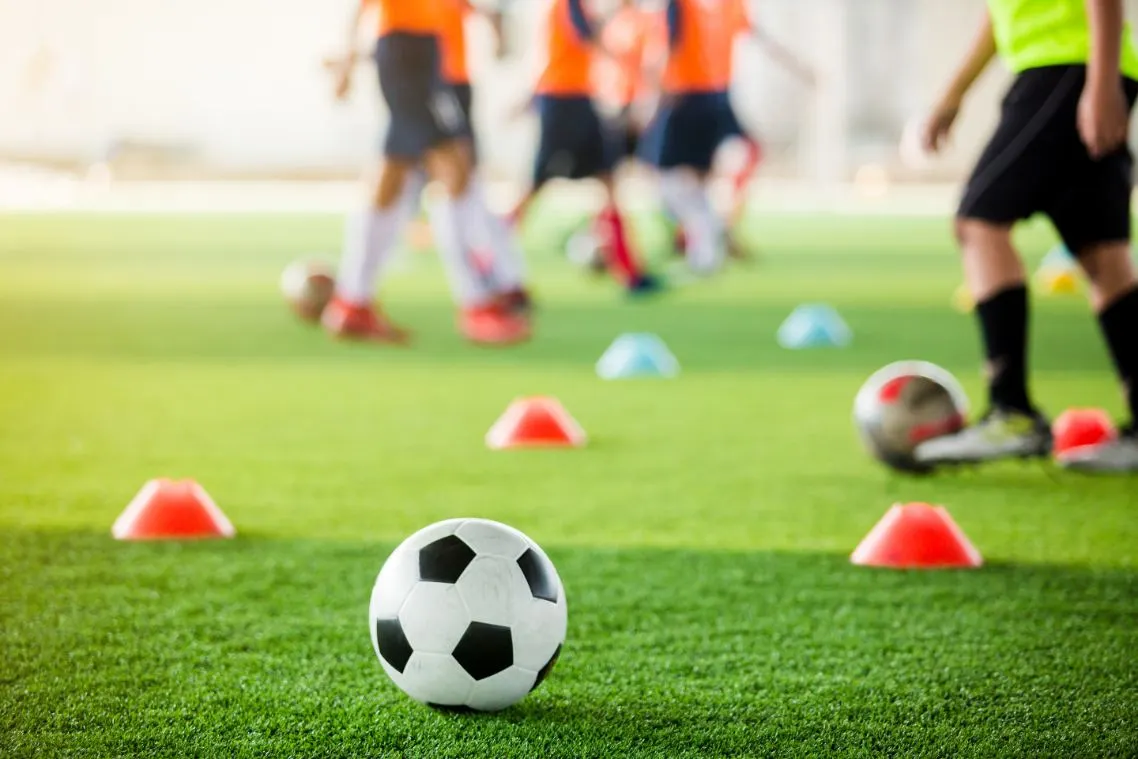 Children playing soccer on astro turf in Orange County