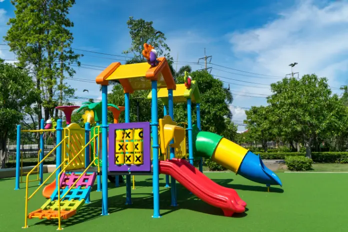 Artificial turf for playgrounds with a childrens slide installed